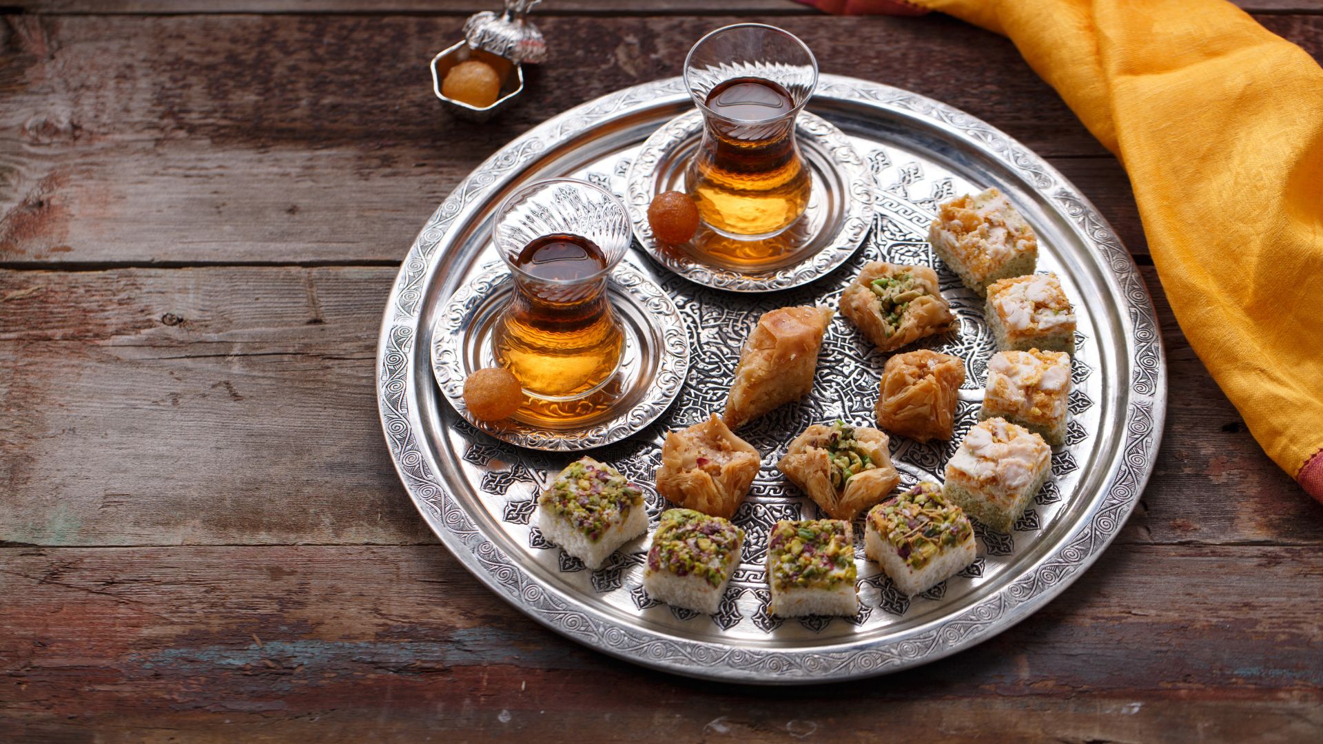 Baklava, das ikonische Dessert aus dem Nahen Osten, ist nicht nur für seinen unwiderstehlichen Geschmack bekannt, sondern auch für die Kunst und Weise, wie es traditionell genossen wird. In der Türkei, einem Land mit einer langen Baklava-Tradition, ist es üblich, dieses süße Gebäck mit türkischem Tee oder türkischem Mokka zu begleiten.</p>
<p>Der türkische Tee, auch als Çay bekannt, ist eine wichtige kulturelle Institution in der Türkei. Er wird aus speziellen Teekannen, den sogenannten Samowaren, zubereitet und in kleinen, dekorativen Gläsern serviert. Der leichte und erfrischende Geschmack des Tees bildet eine harmonische Ergänzung zu der süßen Intensität des Baklavas. Die Bitterkeit des Tees hilft dabei, die süßen Aromen des Desserts auszugleichen und den Gaumen zu reinigen, um den vollen Genuss des Baklavas zu ermöglichen. Es ist eine köstliche Kombination, bei der sich die unterschiedlichen Geschmacksprofile gegenseitig ergänzen und ein vollmundiges Geschmackserlebnis schaffen.